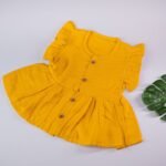 Mustard Yellow Muslin Baby Frock with Wooden Buttons – Soft & Stylish